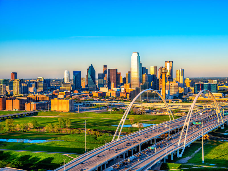 Dallas city skyline with interstate bridges over green land
